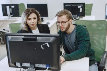 Twee collega’s werken samen bij een computer
